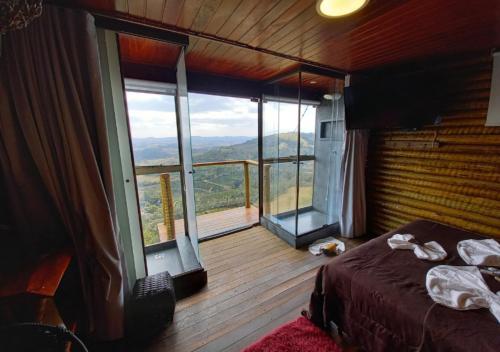 a bedroom with a bed and a large window at Pousada do Xerife in Caconde