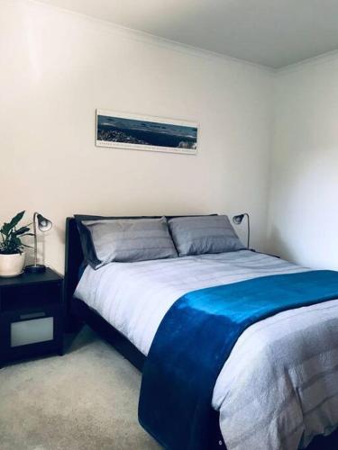1 dormitorio con 1 cama con manta azul en Snowcapped Peaks, en Mount Beauty