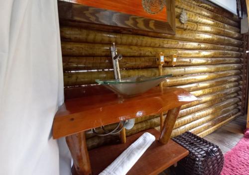 a bathroom with a sink in a wooden wall at Pousada do Xerife in Caconde
