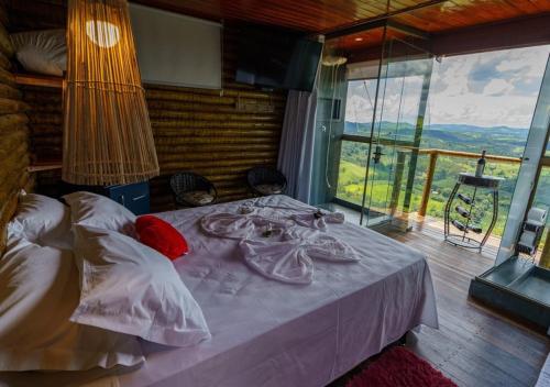 a bedroom with a bed and a large window at Pousada do Xerife in Caconde