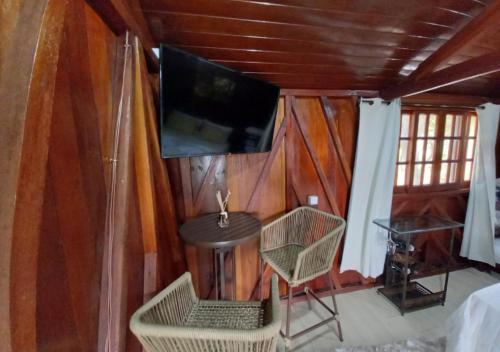 a room with a table and a tv on a wall at Pousada do Xerife in Caconde