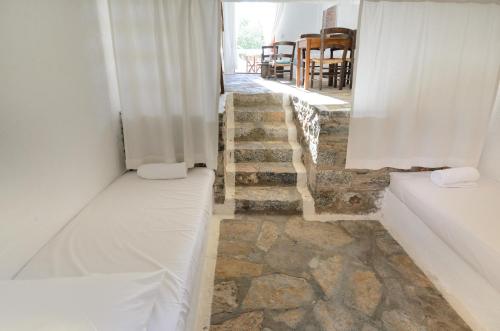 a room with two beds and a stone floor at Elounda Island Villas in Elounda