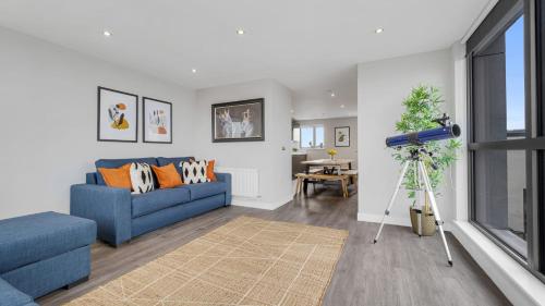 ein Wohnzimmer mit einem blauen Sofa und einem Tisch in der Unterkunft Host & Stay - The Baltic Penthouse 2 in Liverpool