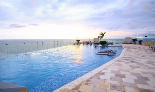 una piscina con el océano en el fondo en Cerca al Hotel Americas Ctgna Spiaggia Morros Piscina playa, en Cartagena de Indias