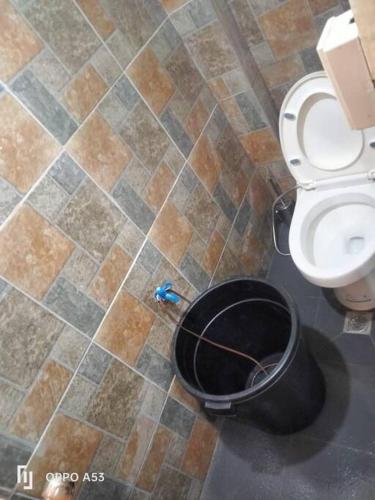 a bathroom with a toilet and a trash can at TerisitaPlace - DriveBy RestStop in Taytay