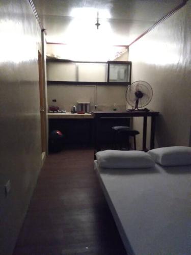 a room with a bed and a kitchen with a fan at TerisitaPlace - DriveBy RestStop in Taytay