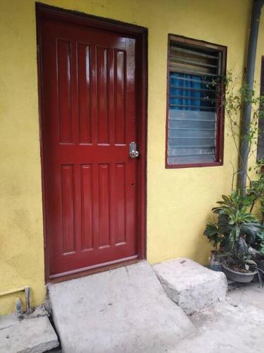 a red door of a house with a window at TerisitaPlace - DriveBy RestStop in Taytay