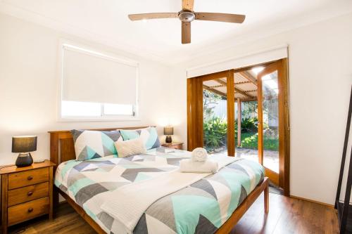 a bedroom with a bed and a window at Sunbaker Pet Friendly Awards Finalist 4 Mins Walk to Culburra Beach in Culburra Beach