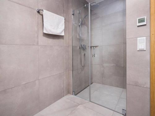 La salle de bains est pourvue d'une douche avec une porte en verre. dans l'établissement Exclusive chalet with sauna and unique view of the glacier, à Neukirchen am Großvenediger
