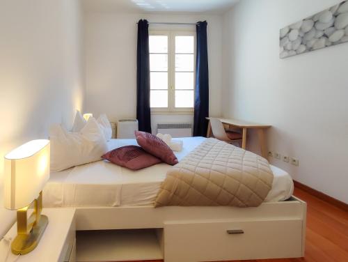 sypialnia z dużym białym łóżkiem i oknem w obiekcie Grimaldi Centrale 5 Pers Wi-Fi AC w Nicei