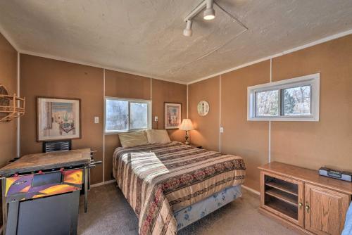 um quarto com uma cama, uma secretária e 2 janelas em Buena Vista Creekside Home with Private Hot Tub! em Buena Vista