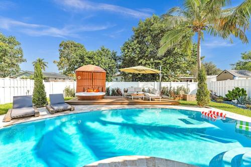 a swimming pool with two chairs and a gazebo at Luxury Hollywood Home, Heated Pool, Casino Nearby in Hollywood