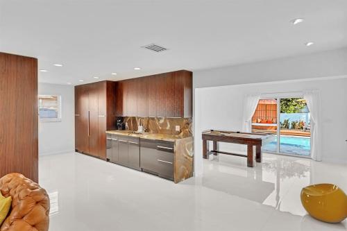 a kitchen with wooden cabinets and a table at Luxury Hollywood Home, Heated Pool, Casino Nearby in Hollywood