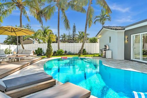 a swimming pool in the backyard of a house with palm trees at Luxury Hollywood Home, Heated Pool, Casino Nearby in Hollywood