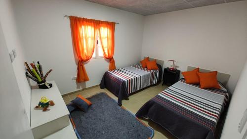 Habitación pequeña con 2 camas y ventana en Descubre & Descansa en Tupungato