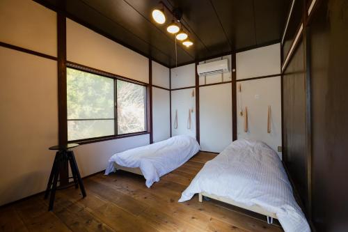 een kamer met twee bedden en een camera erin bij kamadoma in Kure