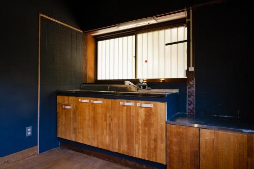 eine Küche mit einem Waschbecken und einem Fenster in der Unterkunft kamadoma in Kure