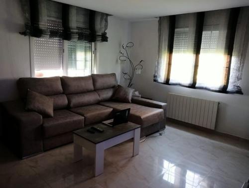 a living room with a brown couch and a coffee table at Chalet Costa Dorada in Tarragona