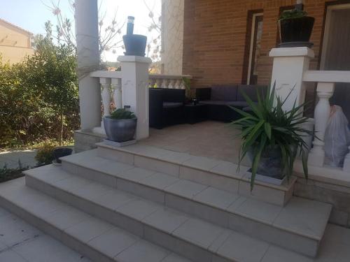 um pátio com escadas e vasos de plantas numa casa em Chalet Costa Dorada em Tarragona