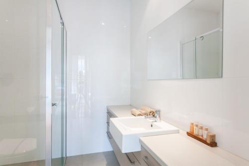 a white bathroom with a sink and a shower at Anglesea River Apartment 22 in Anglesea