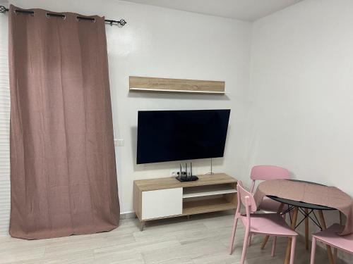 a living room with a tv and a table and chairs at CASA PARAISO 3 in Corralejo