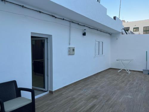 a room with a white wall and a chair at CASA PARAISO 3 in Corralejo