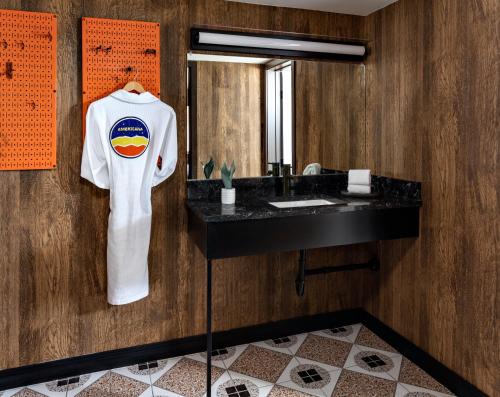 a white shirt hanging on a wall in a bathroom at Americana Motor Hotel in Flagstaff