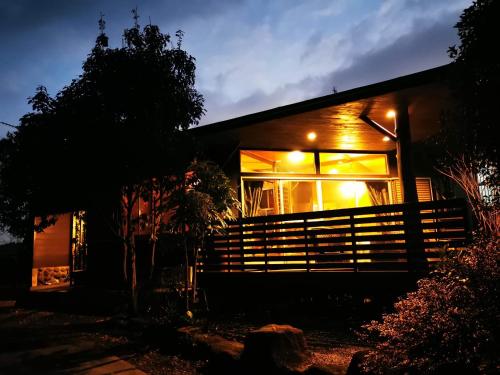 a house with lights in the window of it at プライベート温泉付き隠れ家　Shankara Lodge ~stay & retreat~ in Kirishima