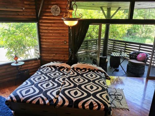 1 dormitorio con 1 cama en una habitación con ventanas en プライベート温泉付き隠れ家　Shankara Lodge ~stay & retreat~, en Kirishima