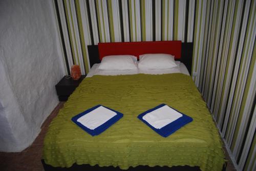 1 cama con manta verde y 2 almohadas en City Centre Duplex Apartment, en Tallin
