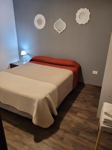 een slaapkamer met een bed met een rode deken bij Departamento Centeno. Centrico. in Santa Rosa