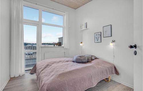 1 dormitorio con cama y ventana grande en 4 Bedroom Stunning Home In Lkken, en Løkken