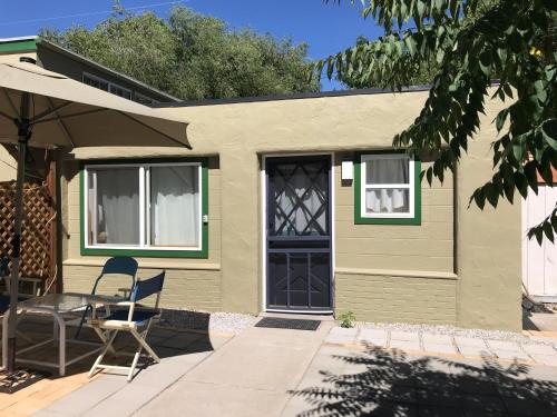 une maison verte avec une porte bleue, une table et une chaise dans l'établissement Funky Urban Studio near UNR, à Reno