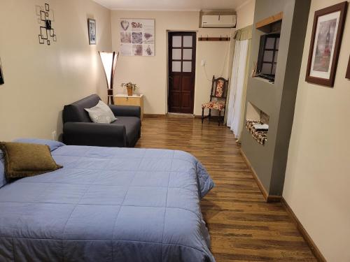 聖羅莎的住宿－Monoambiente amplio, Centrico，一间卧室配有一张床、一张沙发和一把椅子