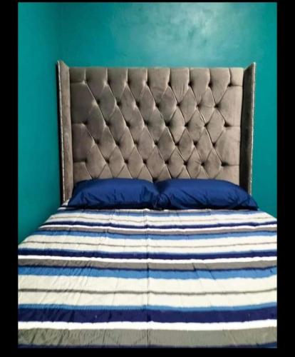 um quarto com uma cama com uma parede azul em Los laureles em Tequila