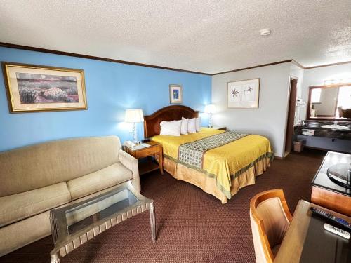 um quarto de hotel com uma cama e um sofá em Night Inn em Sweet Springs