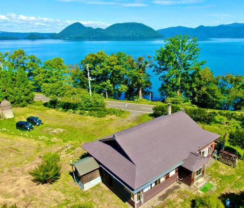 an overhead view of a house with a view of the water at 自然の中の古民家ゲストハウスちゃいはな庵 Organic county style classic house Chaihana an in Lake Toya