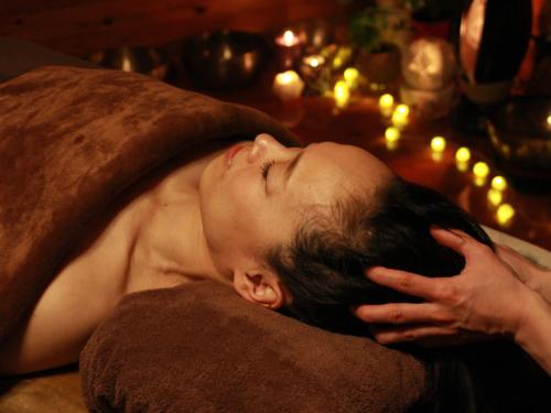 a young man laying on a pillow with his head on a pillow at プライベート温泉付き隠れ家　Shankara Lodge ~stay & retreat~ in Kirishima
