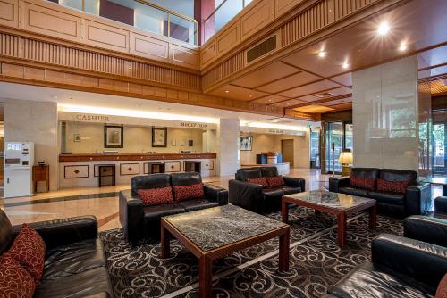 a lobby with couches and tables and a kitchen at International Garden Hotel Narita in Narita