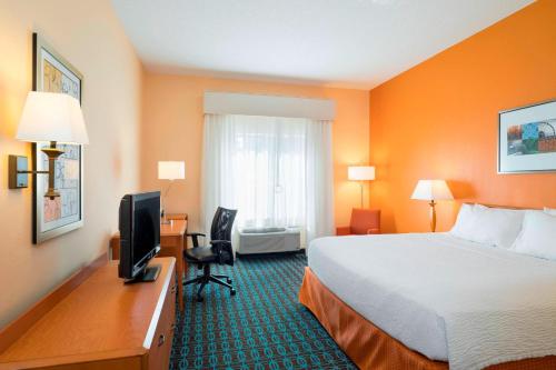 a hotel room with a bed and a desk with a television at Fairfield Inn & Suites by Marriott State College in State College