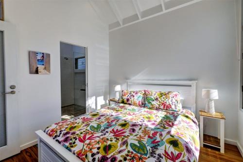 a bedroom with a large bed with a colorful bedspread at Eureka in Boomerang Beach