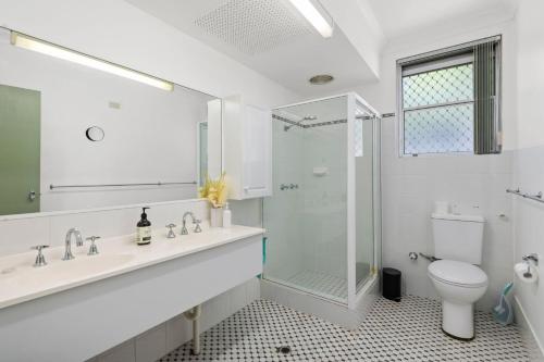 a bathroom with a shower and a sink and a toilet at Bayview Towers in Nelson Bay