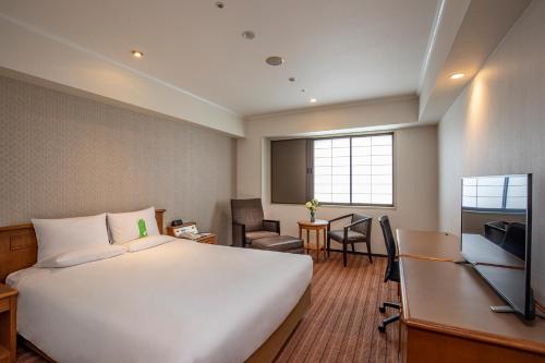 a hotel room with a large bed and a desk at International Garden Hotel Narita in Narita