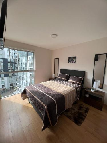 a bedroom with a large bed and a large window at Habitacion privada Habbey road en dpto compartido. in Lima