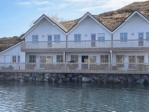 a large white house on a bridge over water at 6 person holiday home in Kverva in Dyrvik