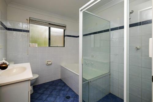 a bathroom with a shower and a sink at Far Shore in Seal Rocks