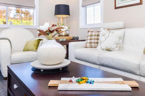 a living room with a vase on a table at Sweet Magnolia 1 or 2 BR Suite St Kilda Cambridge with Complimentary Continental Breakfast in Cambridge