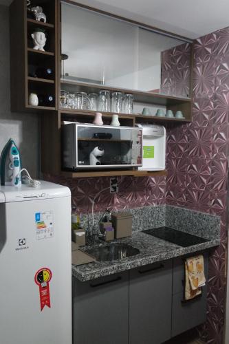 a kitchen with a microwave and a refrigerator at Sp Bras, Apartamento inteiro, Expo Center Norte, Vinho Grátis, feira da madrugada, Rua vautier, Rua 25 de março, Templo, Pari in Sao Paulo