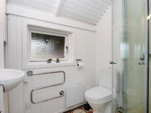 a white bathroom with a toilet and a sink at Holiday home Toftlund XI in Toftlund