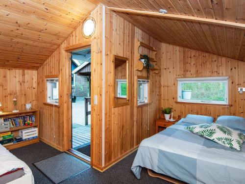 ToftlundにあるHoliday home Toftlund XIの木製の壁のベッドルーム1室、ベッド1台が備わります。